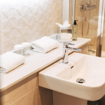 Elegant hotel bathroom with modern sink, plush towels, soothing tiles, and luxury amenities for a relaxing stay.
