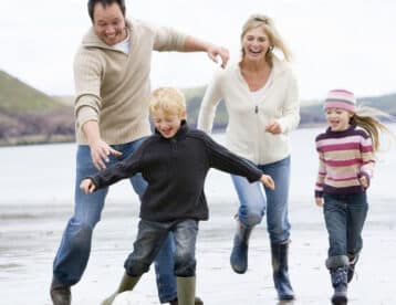 Family playing football on winter beach