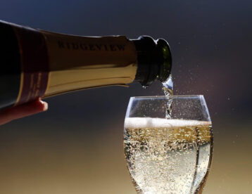 Sparkling wine being poured into a glass, capturing bubbles; enjoy luxury hotel amenities and a relaxing stay.