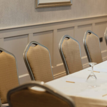 Elegant hotel meeting room with modern decor, stylish chairs, and a pristine conference table set for a professional event.