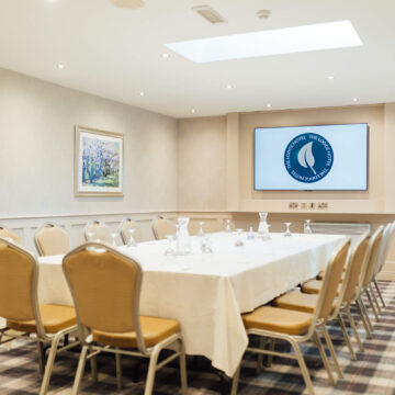 Elegant meeting room with natural light, modern amenities, and comfortable seating for business or events.